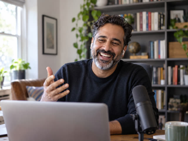 A remote guest laughing on camera (illustrative photo)